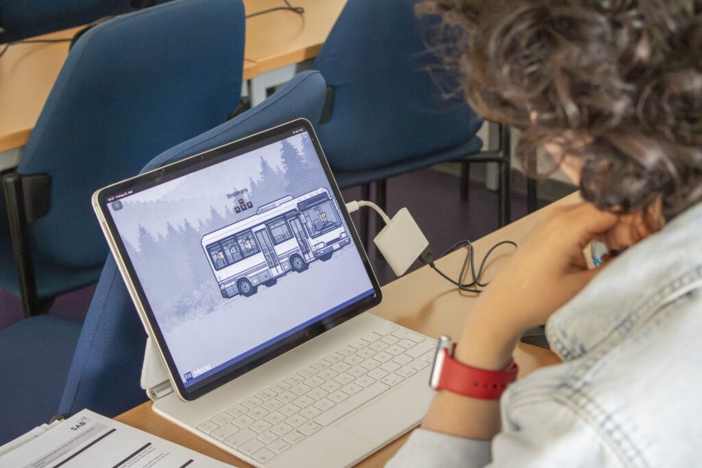 Person von hinten, welche den spielbasierten Einstieg auf ihrem Laptop testet